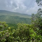 61.  La Vallée Heureuse est au bas du rempart derrière la végétation au premier plan. Sous les nuages de droite la forêt de Mare Longue..jpeg